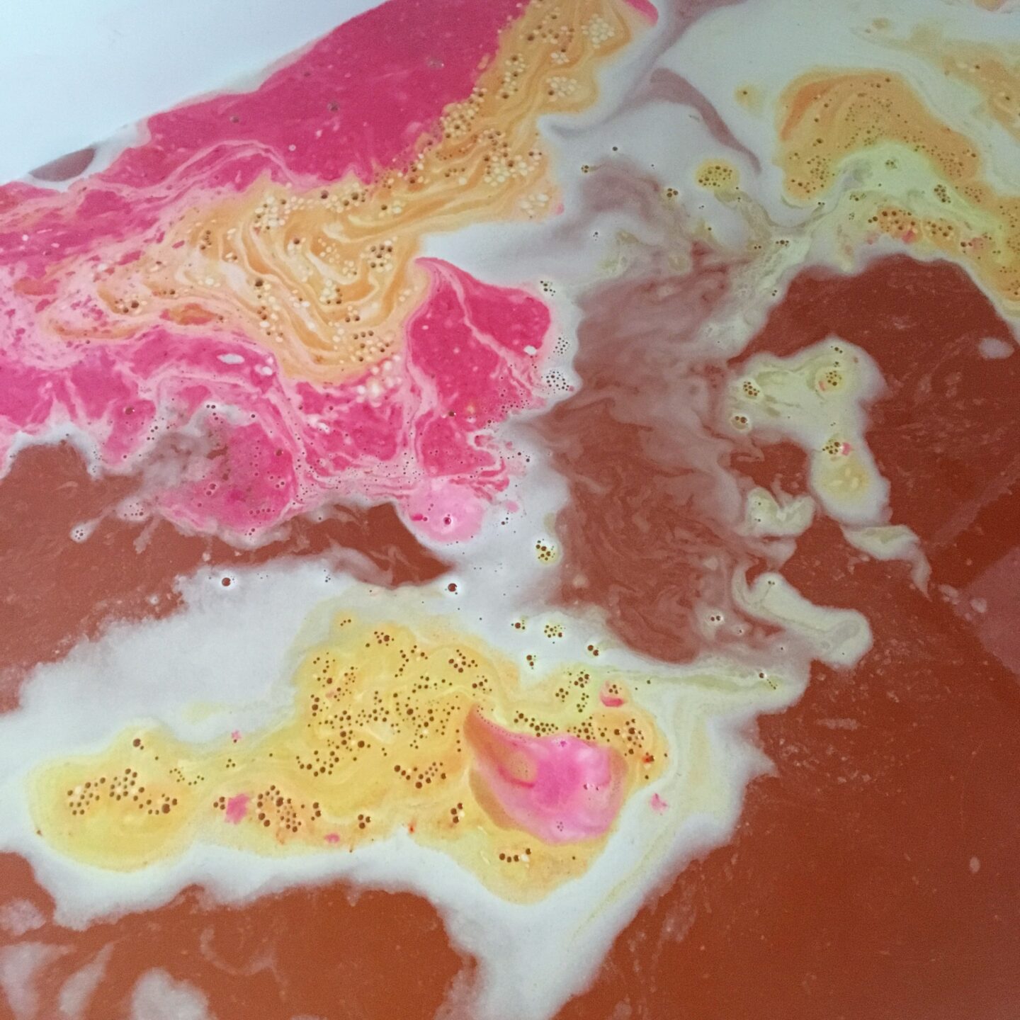 closeup of the pink and orange foam on top of the water